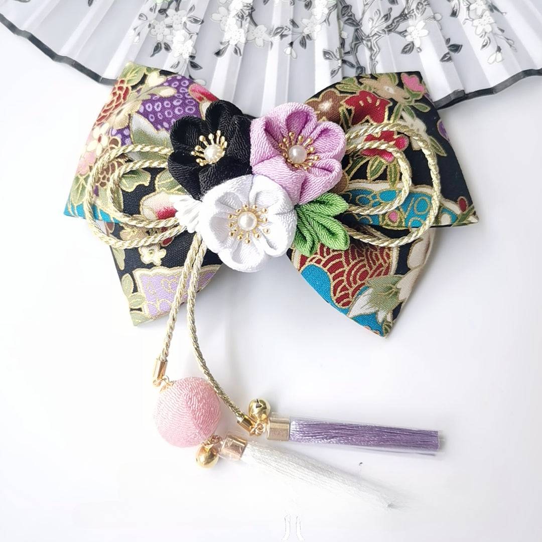 Black floral Japanese kimono hair clip with purple, white, and black cherry blossoms and gold rope bow.