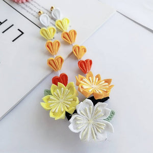 Dangling yellow and orange sakura hairpins with heart-shaped petals, from the Japanese kimono headdress set.
