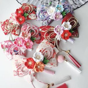 Assorted Japanese kimono hair accessories with floral bows, cherry blossom designs, and colorful tassels for lolita styling.