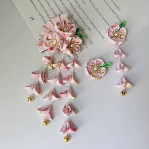 Pink kimono hair accessory set with five-petal flowers, fan design, and hanging tassels with gold bells for traditional Japanese wear.