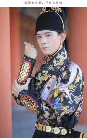 Detailed view of gold dragon-scale arm guards worn with ornate black Chinese costume