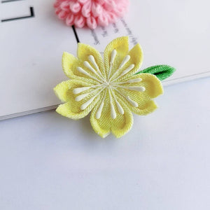 Single yellow cherry blossom hairpin with green leaf, ideal for accessorizing traditional Japanese attire.