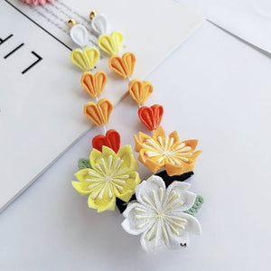 Dangling yellow and orange sakura hairpins with heart-shaped petals, from the Japanese kimono headdress set.