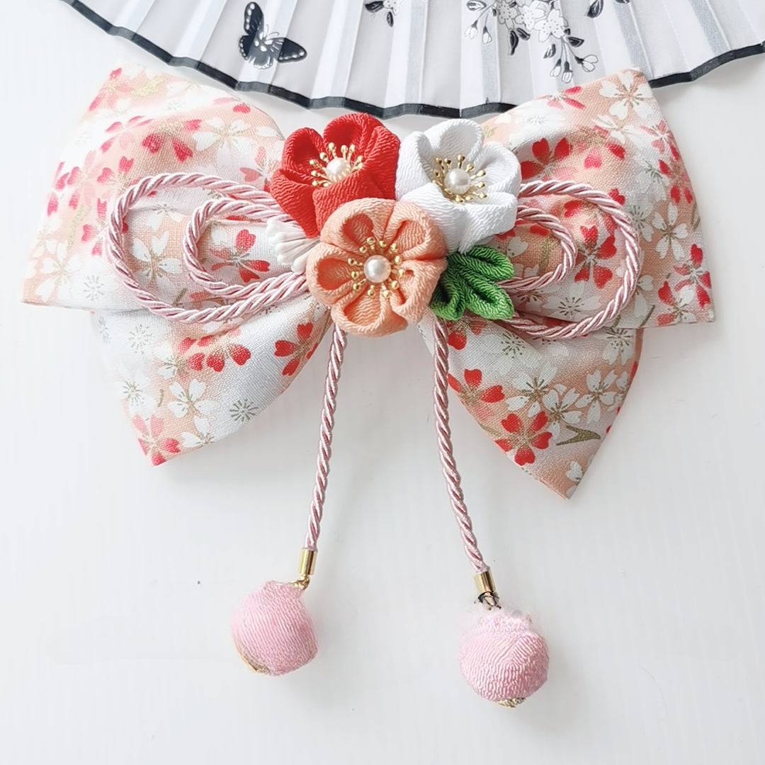 Peach floral Japanese kimono hair accessory with orange and white cherry blossoms and soft pink ball tassels.
