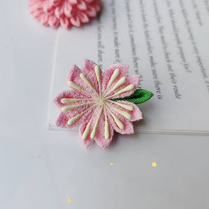 Single pink cherry blossom hairpin with green leaf, part of the Sakura 4-piece Japanese kimono accessory set.