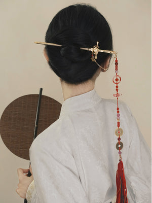 Elegant Hanfu hairstyle adorned with a gold sword hairpin and red tassel, showcasing traditional Chinese accessory craftsmanship.