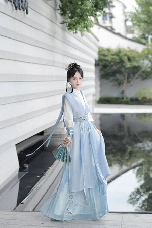 Blue hanfu dress for women, blending traditional Song Dynasty and modern Chinese styles, crafted from luxurious silk. This versatile hanfu includes options for a matching coat or jacket, making it suitable for winter wear, Chinese New Year celebrations, or casual outings. Ideal for occasions like graduations or cosplay, this dress embodies the fairy-inspired elegance of classic hanfu while also drawing from martial arts clothing and contemporary Chinese fashion. Available for purchase in our online hanfu sh