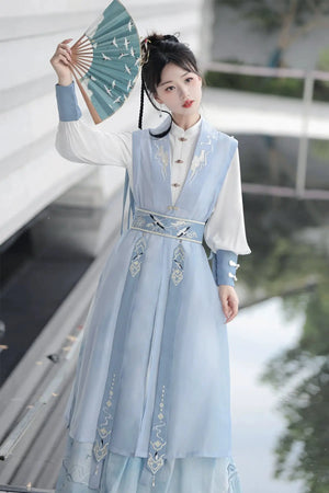 Blue hanfu dress for women, blending traditional Song Dynasty and modern Chinese styles, crafted from luxurious silk. This versatile hanfu includes options for a matching coat or jacket, making it suitable for winter wear, Chinese New Year celebrations, or casual outings. Ideal for occasions like graduations or cosplay, this dress embodies the fairy-inspired elegance of classic hanfu while also drawing from martial arts clothing and contemporary Chinese fashion. Available for purchase in our online hanfu sh
