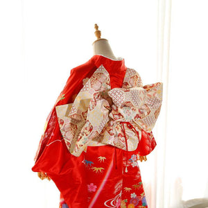 Back view of red kimono with cream patterned big three-leaf bow belt. Swinging sleeves and geisha-style belt bag complete the look.