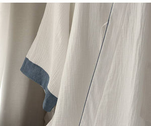 Side view of Chinese style white Hanfu robe highlighting breathable cotton fabric and subtle blue piping detail.