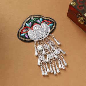 Guizhou Miao fridge magnet with red floral embroidery and long silver fringe, handmade to reflect ethnic cultural heritage.