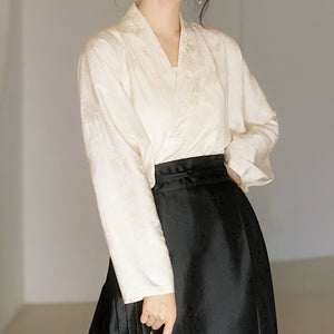 Classic cream Hanfu blouse with floral jacquard pattern, styled with a black traditional skirt for a minimalist Ming-dynasty look.