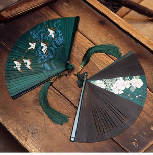 Green and black bamboo folding fans with crane and floral designs. Includes matching green tassels for Hanfu dance.