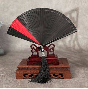 Black and red bamboo folding fan on wooden stand, designed for Hanfu dance. Features full bamboo build and black tassel.