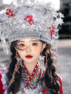 Front view of silver floral headpiece and embroidered neckline on red Chinese Miao pearl wedding dress, ideal for traditional events.