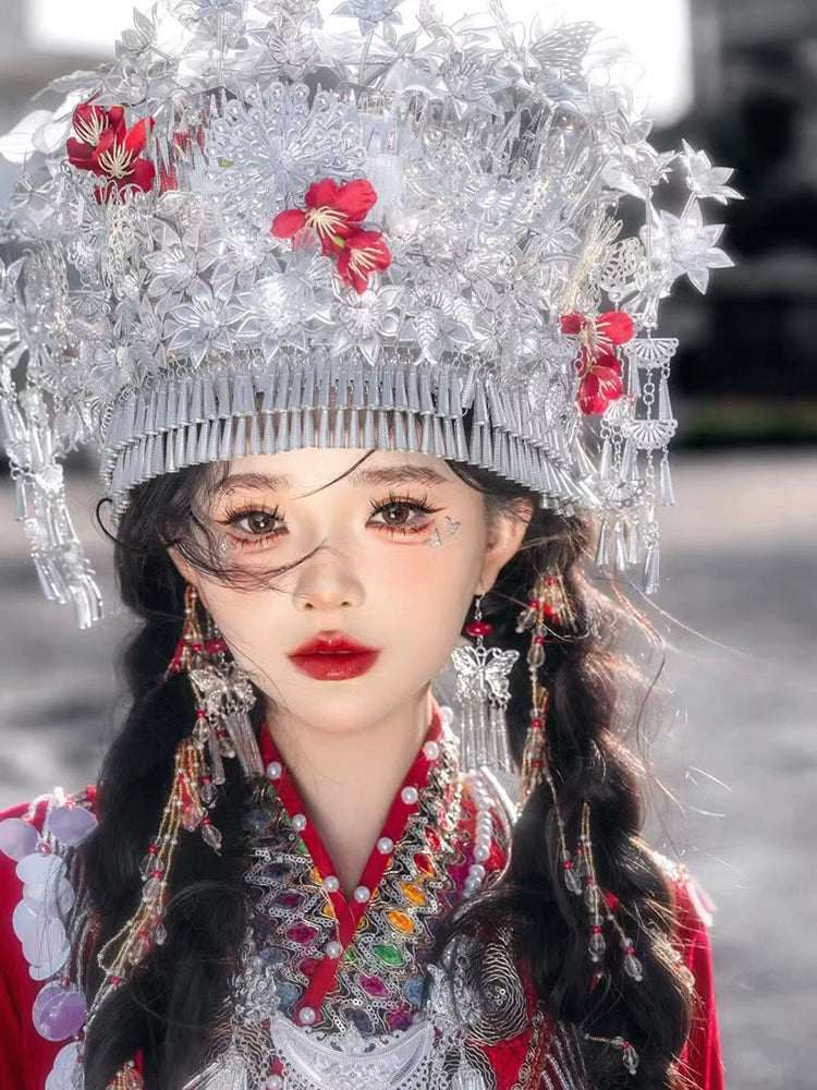 Front view of silver floral headpiece and embroidered neckline on red Chinese Miao pearl wedding dress, ideal for traditional events.