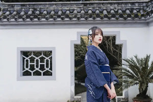Blue Japanese kimono yukata styled in a serene outdoor setting.