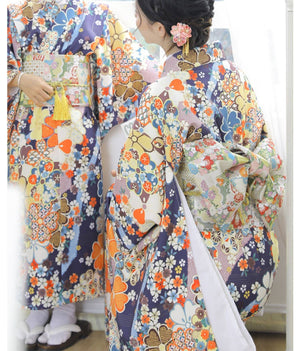 Women wearing colorful floral yukatas with brocade bow belts, showcasing traditional Japanese kimono waist styling for festive occasions.