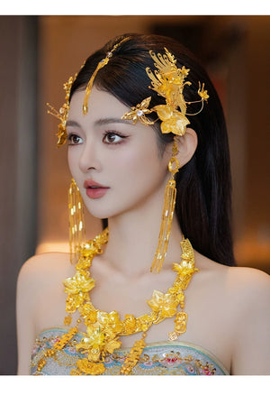 Profile of bride wearing gold Chinese dragonfly hairpin with floral and butterfly accents for cheongsam engagement look.