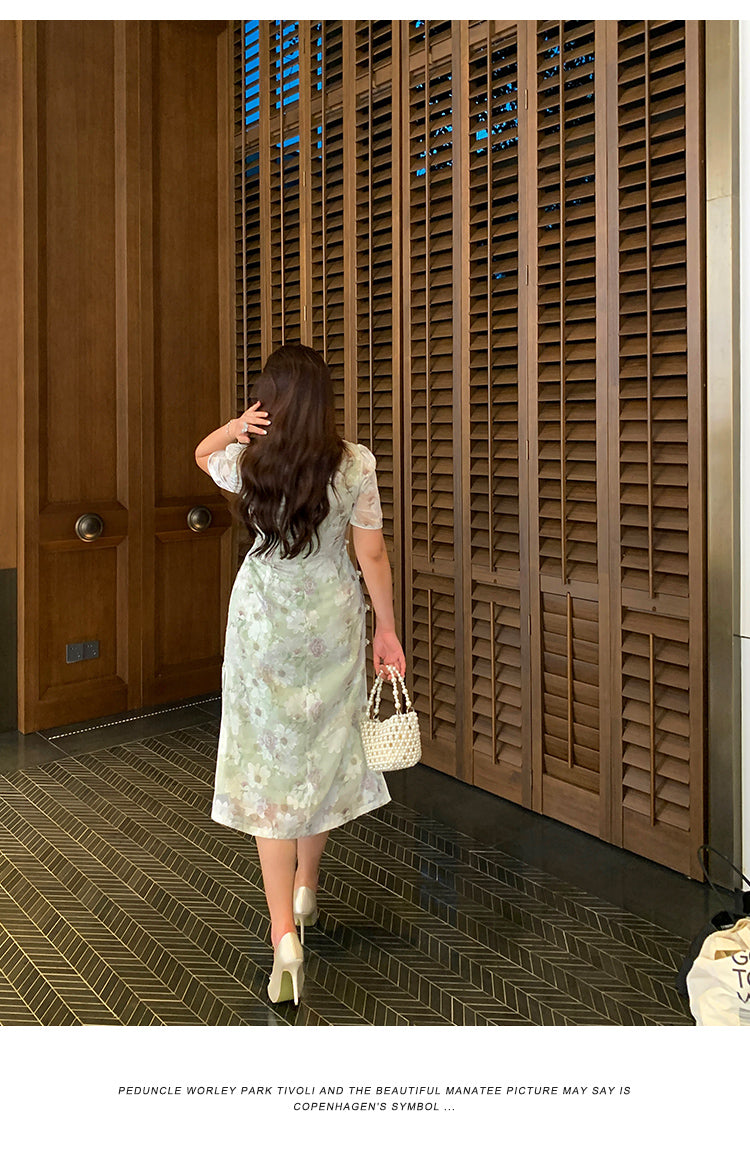 Rear angle of modern Chinese style green plus size cheongsam/qipao, highlighting its flattering fit and delicate floral design.