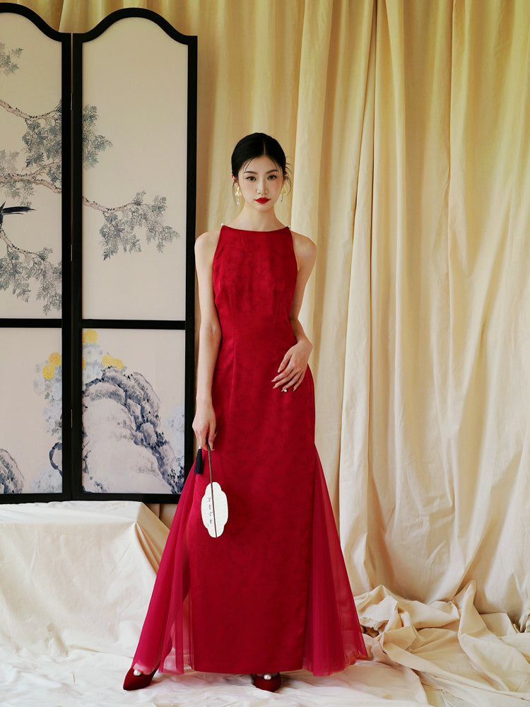 Bride in red cheongsam dress with floral pattern, styled for elegant wedding or engagement occasions.