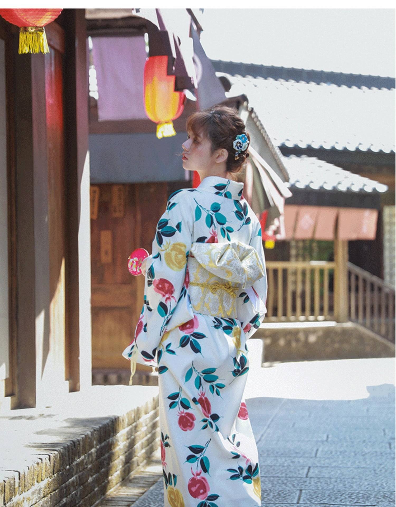 Back view of a woman in floral yukata with a gold brocade bow belt, emphasizing the styling knot waist seal design.