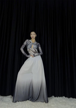 Model wearing watercolor maxi skirt, standing confidently, black curtain
