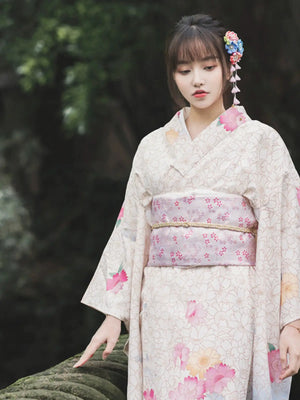 Close-up of a white Japanese kimono with intricate floral patterns and a pastel obi.
