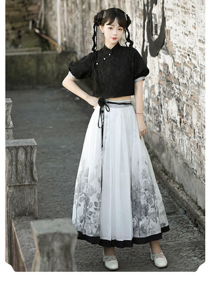 Model posing in New Chinese style black top and floral skirt set, showcasing modern Hanfu elegance for spring and summer.