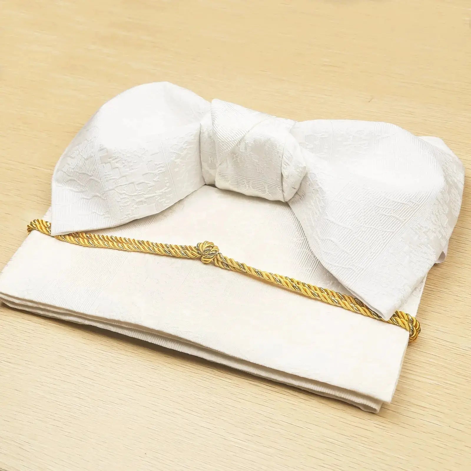White brocade bow belt with gold cord, folded for display, perfect for traditional Japanese yukata waist styling and kimono fashion.