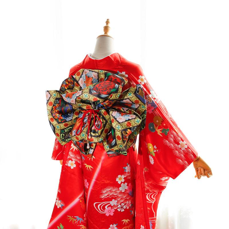 Red kimono with swinging sleeves and black floral big three-leaf bow belt. Geisha-style belt bag adds traditional elegance.