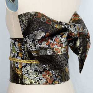 Black floral brocade bow belt styled on mannequin, perfect for Japanese kimono waist seal and yukata fashion for cultural events.