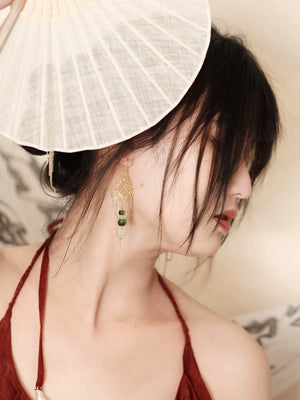 Su Mask Ear Clips - Hanfu Gold Tassel Earrings with floral goldwork and green beads, worn with fan and red Hanfu-inspired outfit.