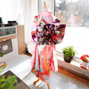 Back view of pink floral kimono with purple big three-leaf bow belt. Swinging sleeves and geisha-style belt bag for elegant wear.