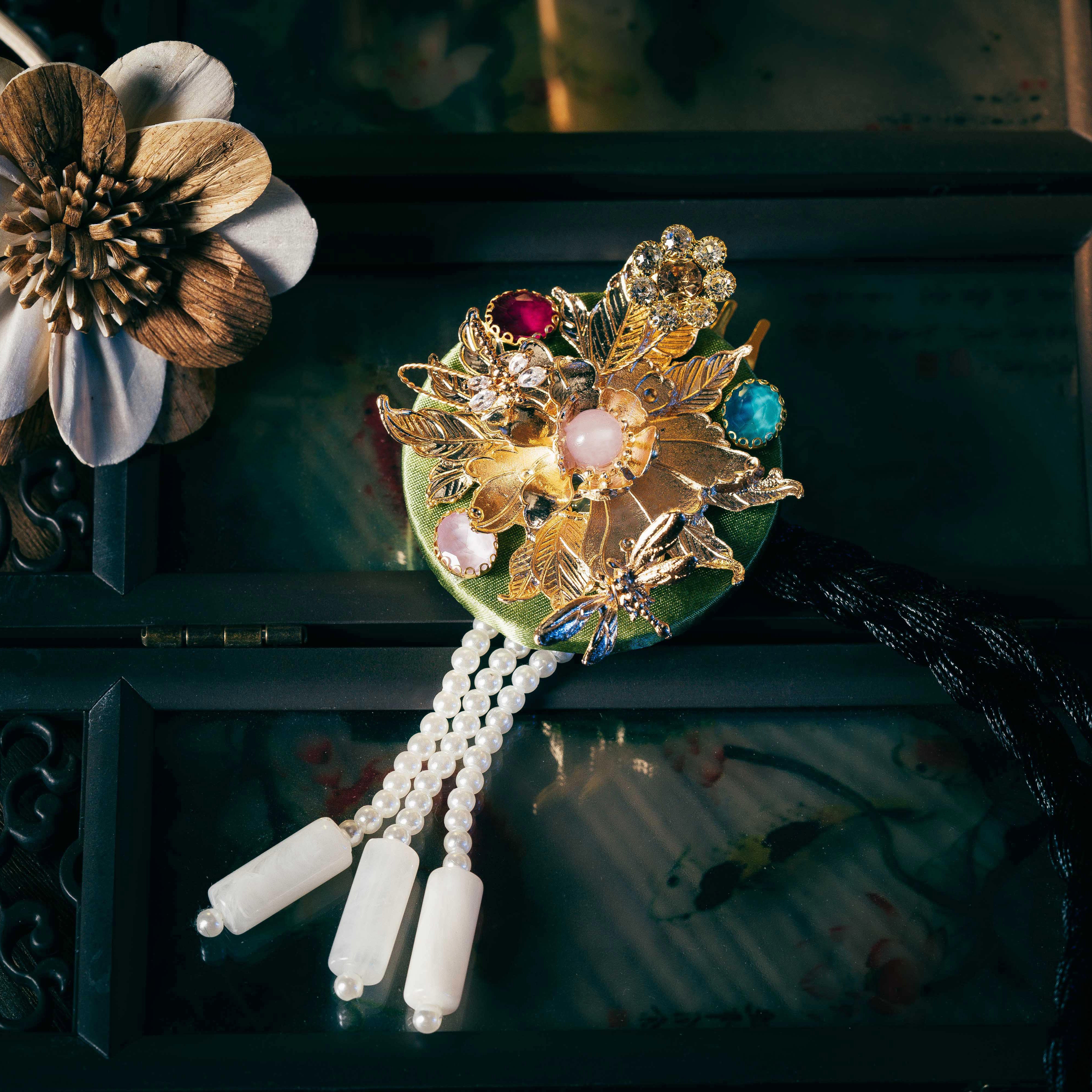 Green-toned Korean traditional headgear with gold floral embellishments and pearl drops, crafted using a precise cutting process.
