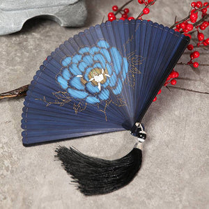 Blue bamboo fan with peony flower design and black tassel, laid flat. Perfect for traditional Chinese dance and Hanfu wear.