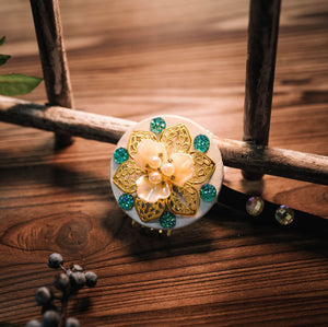 White and green Korean ethnic headgear with floral gold detailing and pearl centerpiece, ideal for traditional outfits.