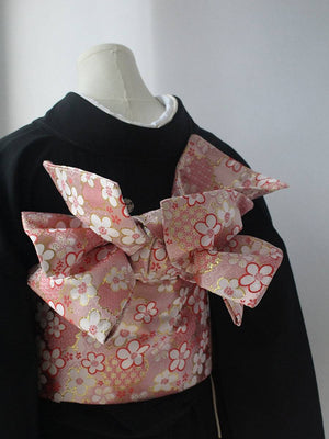 Kimono brocade waist seal in pink floral brocade with oversized bow, worn over black kimono. Elegant 120cm styling accessory.
