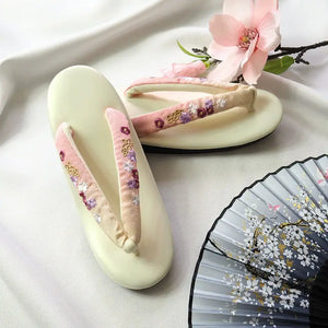 Ivory Japanese kimono sandals with pink floral embroidery and gradient herringbone straps. A charming and elegant footwear option for formal wear.