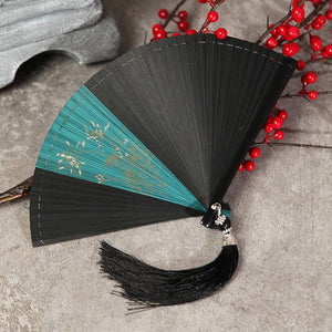 Teal and black bamboo folding fan with floral print and black tassel. Ideal for traditional Chinese dance and Hanfu styling.