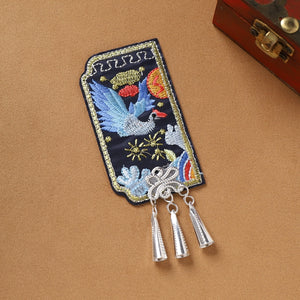 Single Guizhou Miao fridge magnet with blue bird embroidery and silver cone fringe, handmade ethnic decor piece.