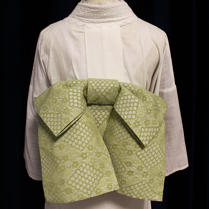 Kimono waist seal styling bow in high-grade green lace, displayed on a mannequin with a white kimono. Elegant and structured design.