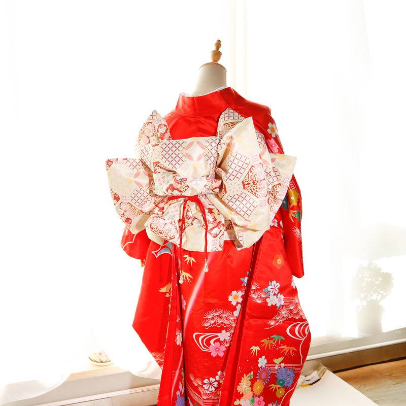 Back view of red kimono with cream and red big three-leaf bow belt. Swinging sleeves and geisha-style belt bag for traditional wear.