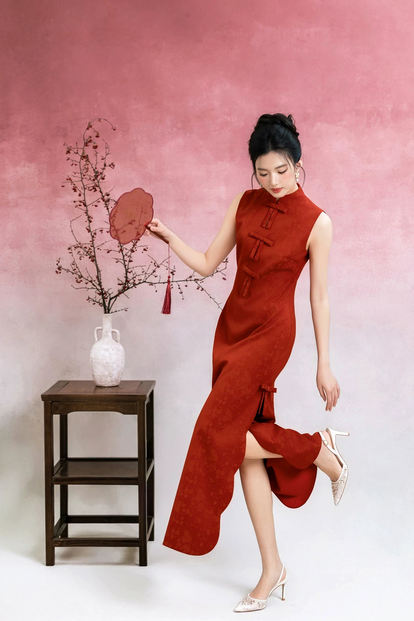 Vermilion red sleeveless bow cheongsam, full-length studio view with fan