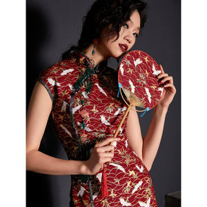 Close-up of red cheongsam with crane print and intricate button details.