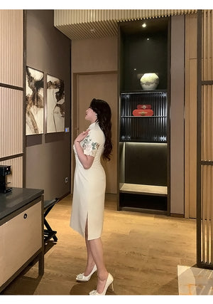 Side view of champagne floral embroidered plus size cheongsam, showcasing slit detail and classic silhouette.