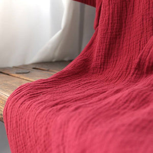 Textured close-up of the red cotton fabric used in the summer Zen nightgown, emphasizing its breathable and lightweight quality.
