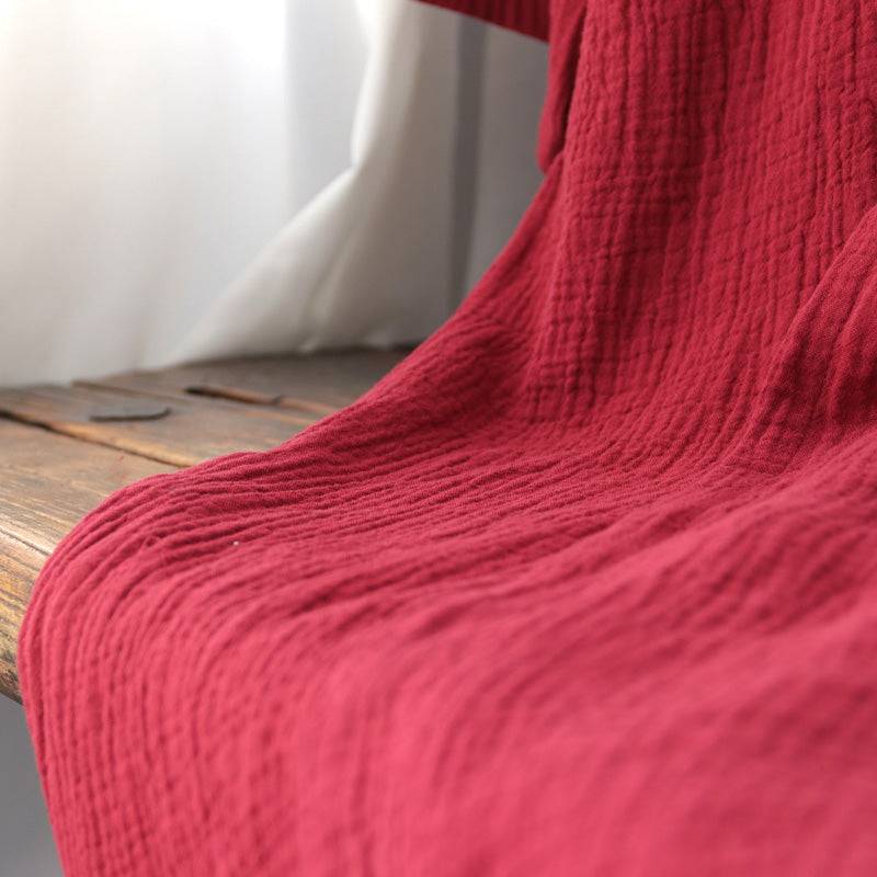 Textured close-up of the red cotton fabric used in the summer Zen nightgown, emphasizing its breathable and lightweight quality.