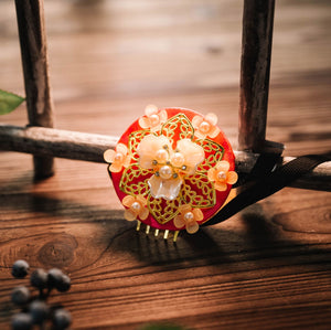 Red Korean traditional headgear with floral pearl design and orange bead accents, perfect for cultural hair styling.