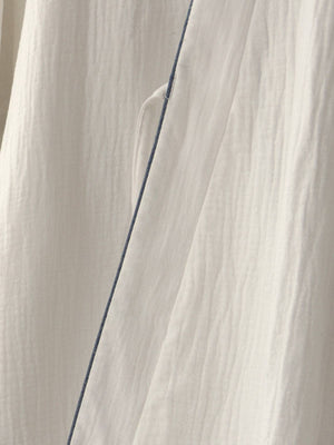Detailed view of pure cotton fabric and side seam of Chinese style white Hanfu robe pajamas, highlighting breathable material.